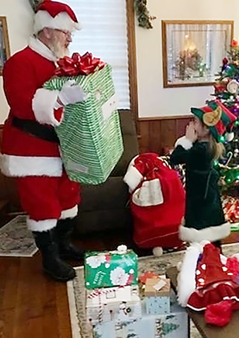 Santa Delivering Gifts To A Young Girl